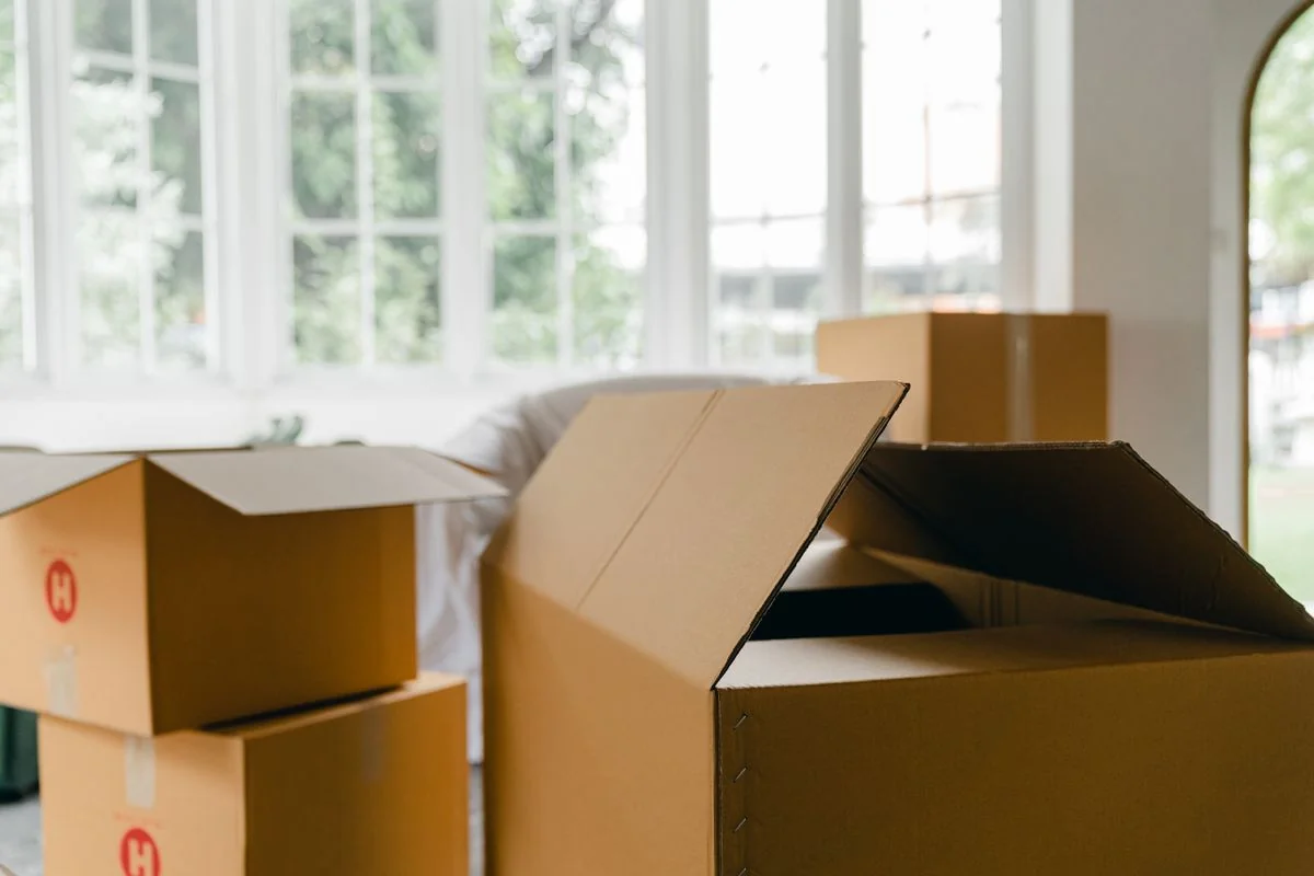 Kartons und abgedeckte Einrichtungsgegenstände in einer Wohnung
